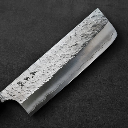Nakiri with hammered blade and engraved characters, captured in a close-up to highlight its details.