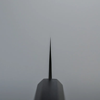 Choil shot of a Kato santoku knife blade photographed from the handle, with the blade pointing upward against a plain gray background.