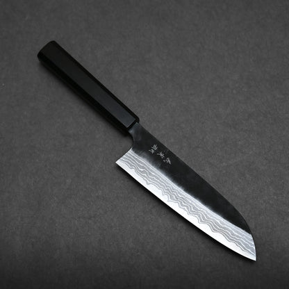 A Kato santoku knife with a black handle and a Damascus-style patterned blade is placed on a dark, textured surface.
