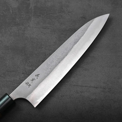 Gyuto with a dark handle, blade engraved in Japanese.
