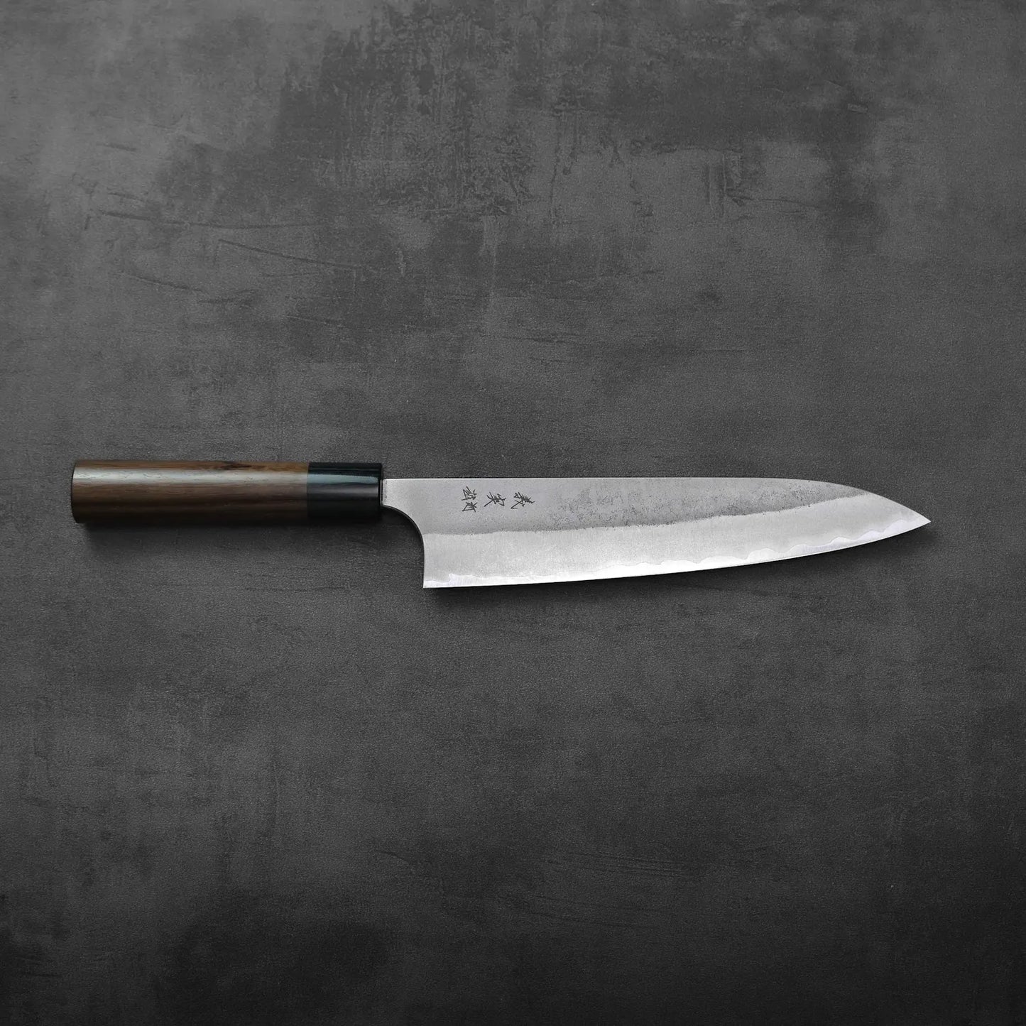 A gyuto with a wooden handle is shown, highlighting the blade and handle details.