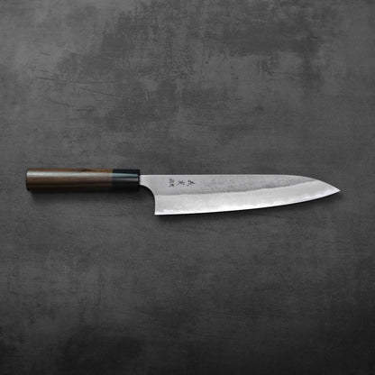 A gyuto with a wooden handle is shown, highlighting the blade and handle details.