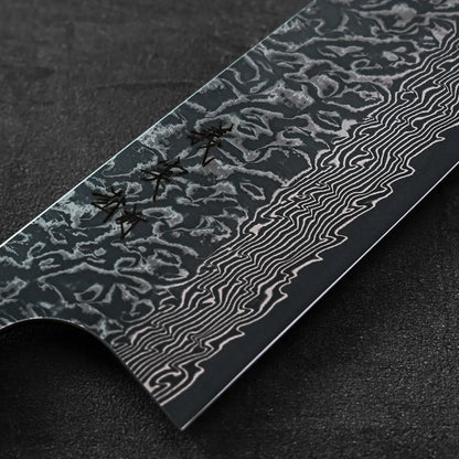 Kiritsuke gyuto blade in close-up with wavy patterns and textured damascus steel visible on the surface.