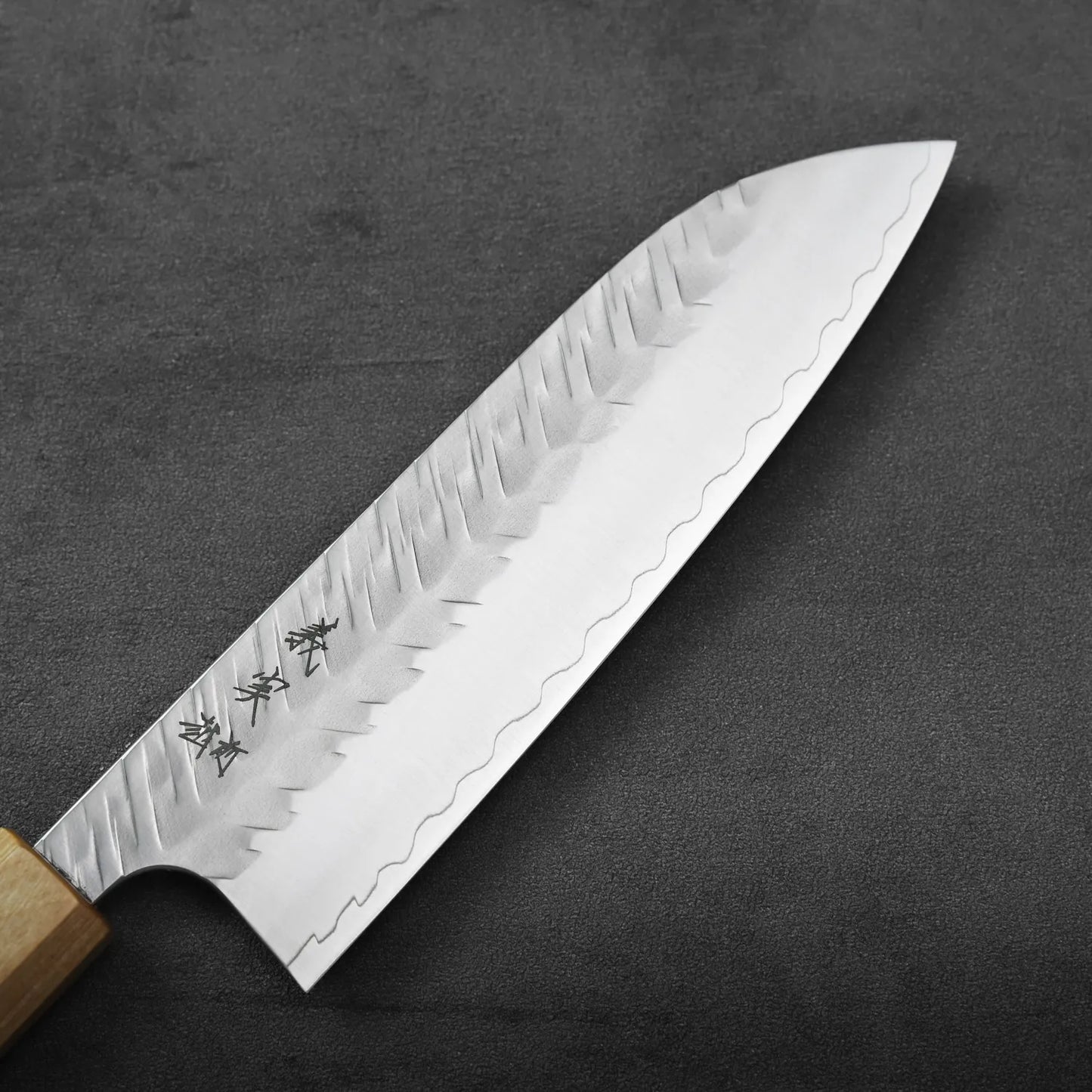 Santoku with a wooden handle and patterned blade.