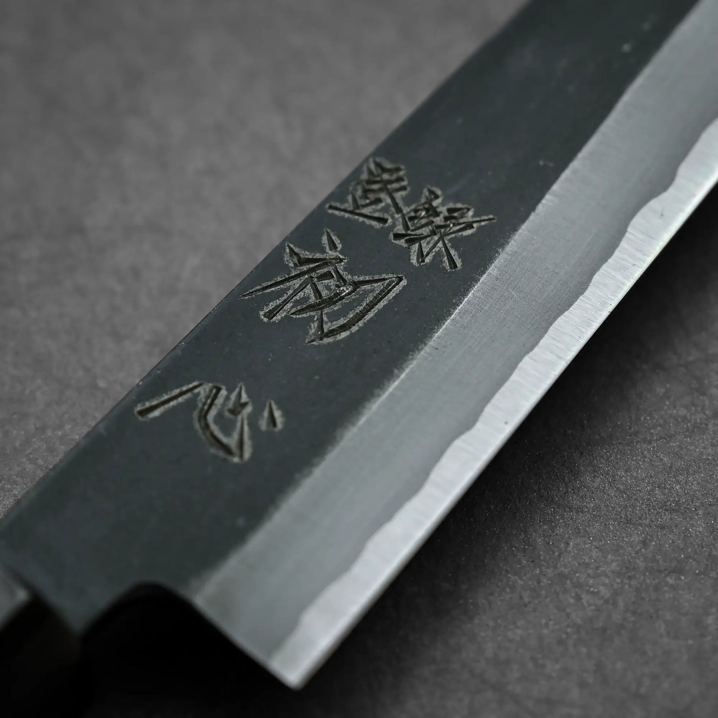 Close-up shot of 150mm Hatsukokoro Aosagi kurouchi aogami#2 petty knife showing maker's mark