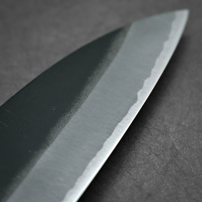 Close-up shot of 180mm Hatsukokoro Aosagi kurouchi aogami#2 santoku knife showing tip area