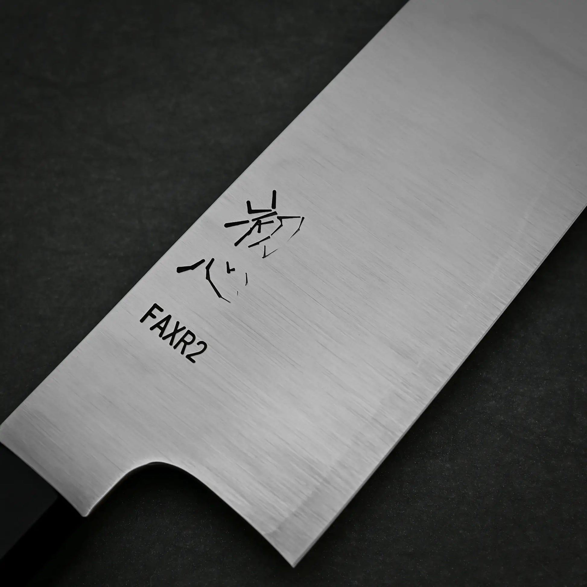 Close-up view of 210mm Hatsukokoro FAXR2 kirituske gyuto knife showing maker's mark