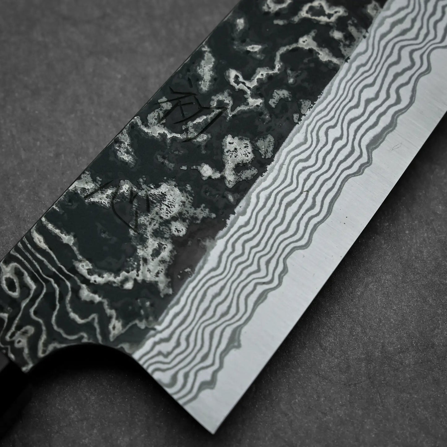 Close-up shot of the kurouchi damascus finish of Nigara knife SLD kurouchi damascus 210mm gyuto