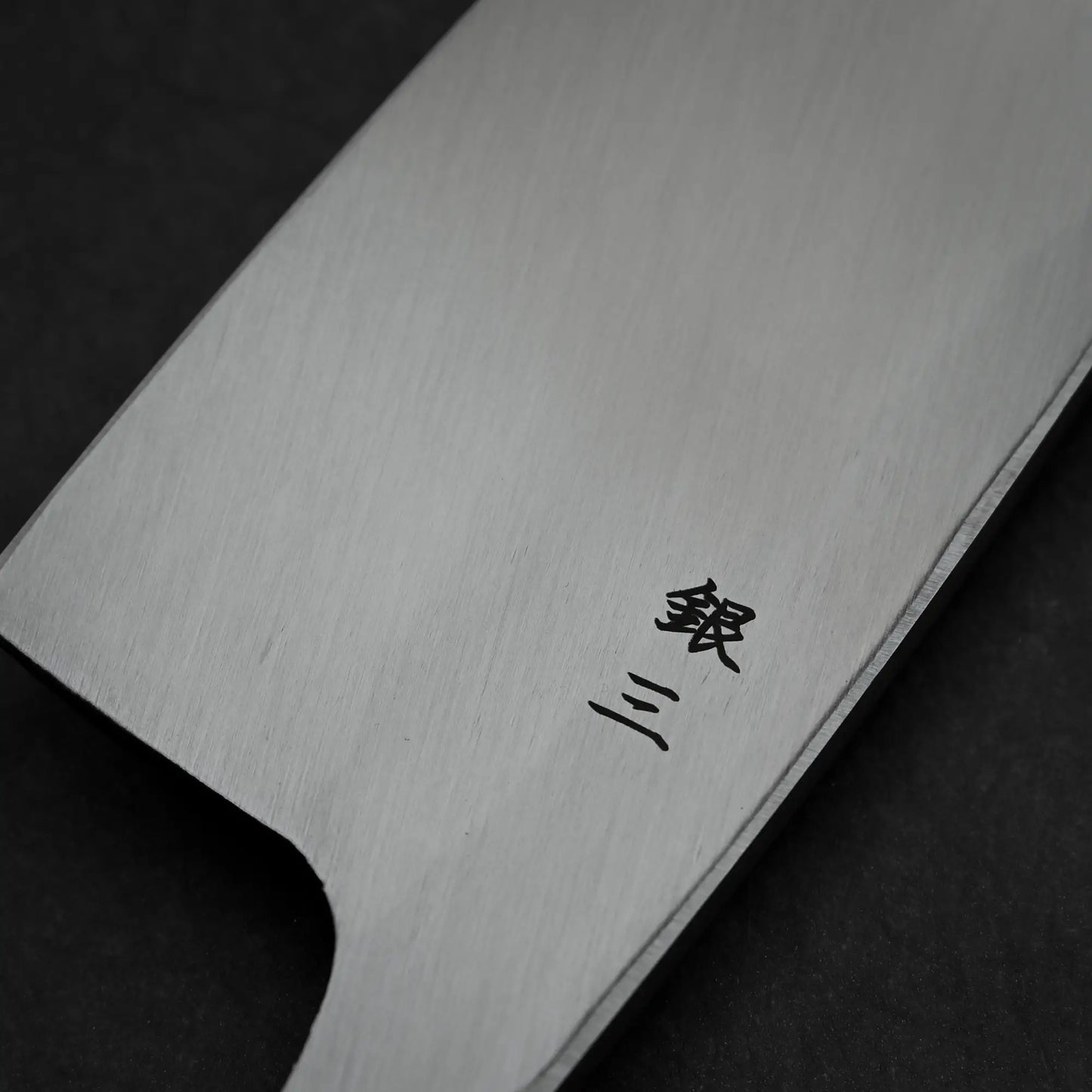 Close-up shot of the kanji on the back side of 180mm Hatsukokoro Shirasagi ginsan deba knife