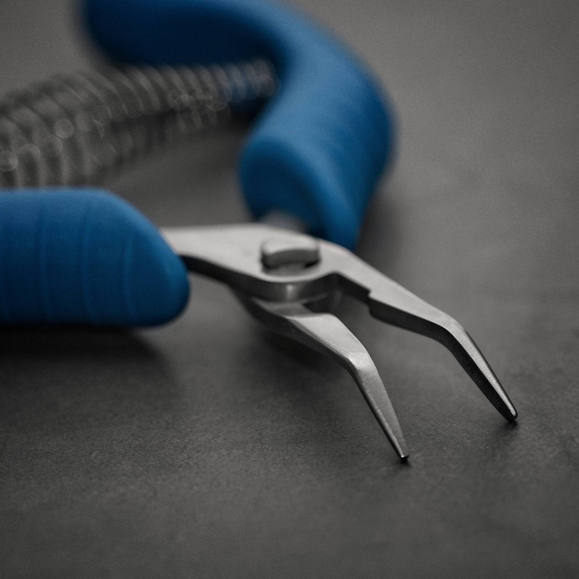 A close up view of Asahi Fish Bone Tweezers made of durable stainless steel with a non-slip grip