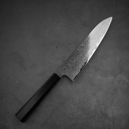 Top view of Hatsukokoro ginsan damascus gyuto 210mm in diagonal position. Tip of the knife is pointing the upper right.