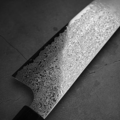 Close up view of the blade of Hatsukokoro ginsan damascus gyuto 210mm. Image focuses on the left side of the blade