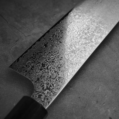Close up view of Hatsukokoro ginsan damascus gyuto 240mm. Image focuses on the left side of the blade.