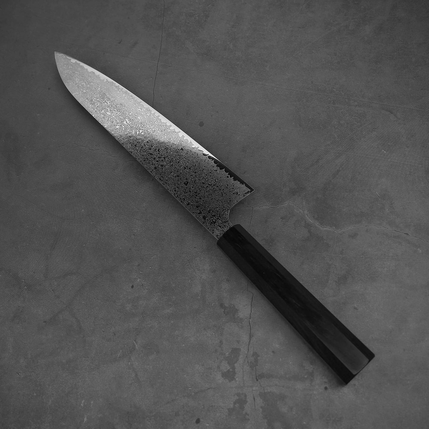 Top view of Hatsukokoro ginsan damascus gyuto 240mm in diagonal position where the tip is facing upper left