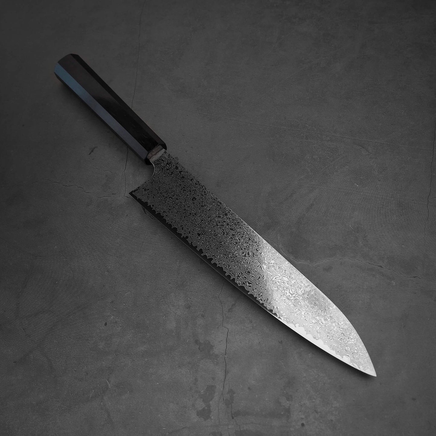 Top view of Hatsukokoro ginsan damascus gyuto 240mm in diagonal position where tip is facing lower right