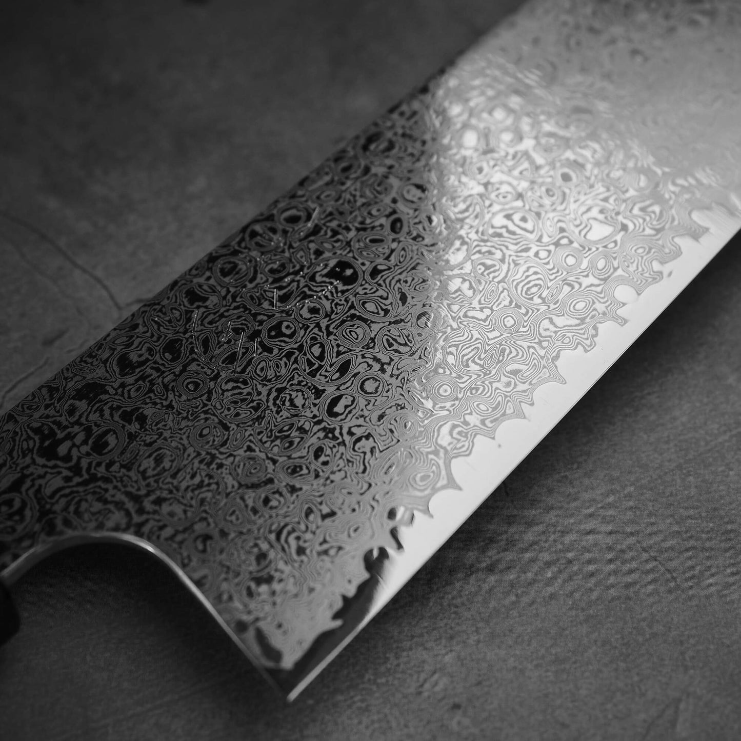 Close up view of the Hatsukokoro ginsan damascus gyuto 240mm. Image focuses on front side of the blade