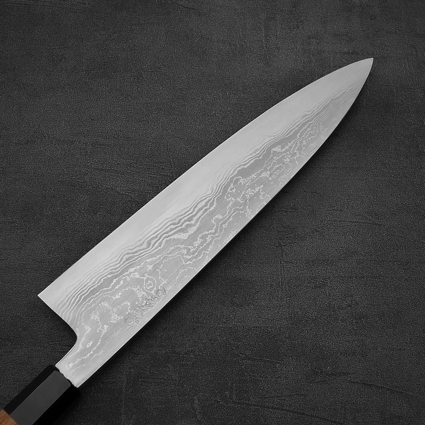 Close up view of Hatsukokoro Komorebi damascus aogami#1 gyuto knife showing the back side of the blade
