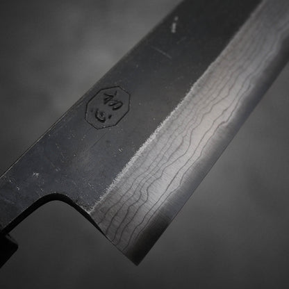 Close up view of Hatsukokoro Kumokage kurouchi damascus aogami#2 bunka knife. Image focuses on the kanji side