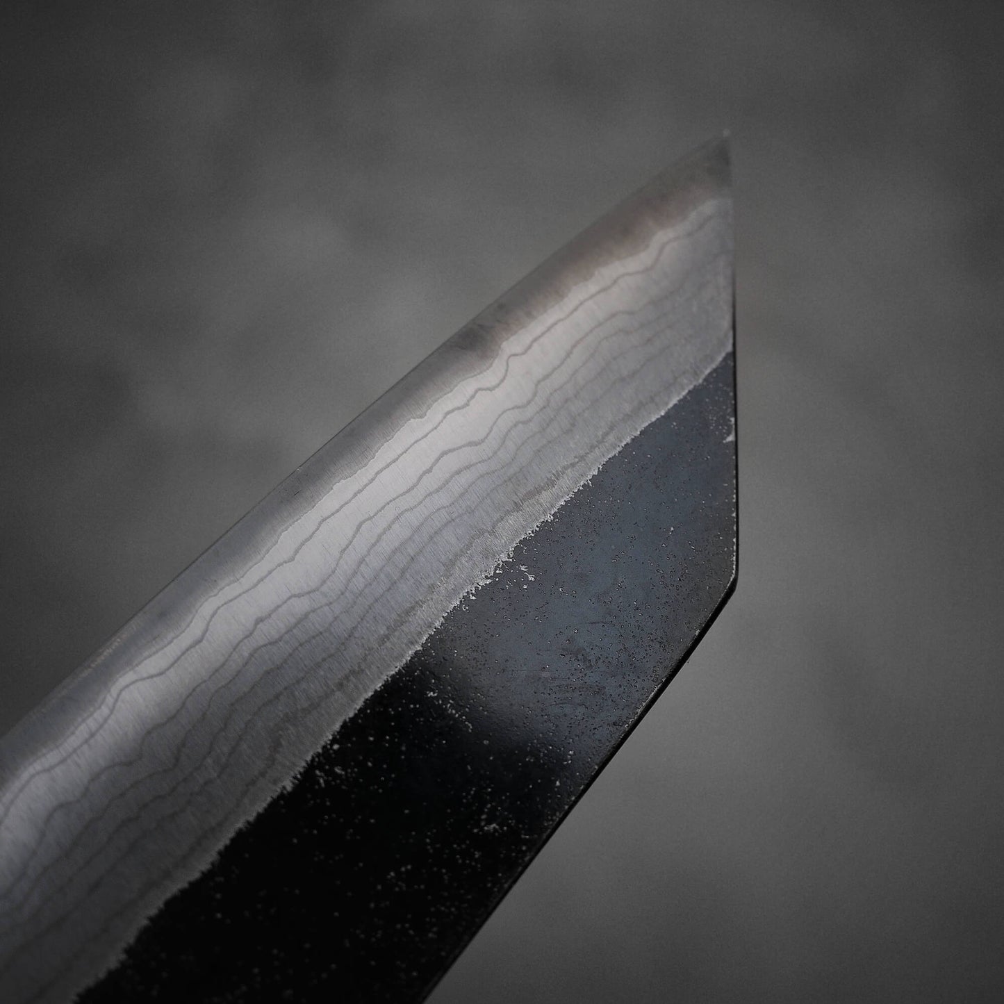 Close up view of the left side of Hatsukokoro Kumokage kurouchi damascus aogami#2 bunka knife