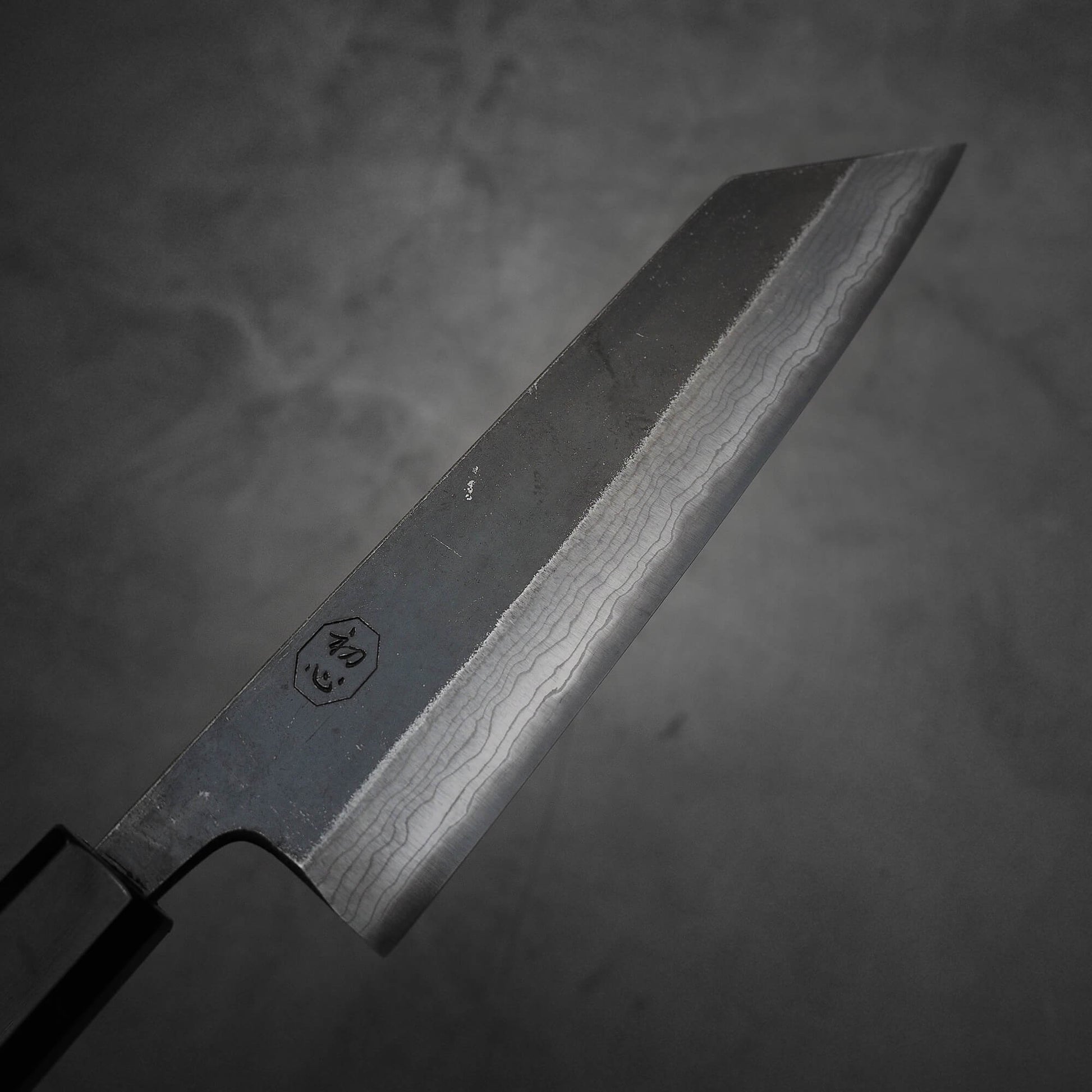 Top view of the blade of Hatsukokoro Kumokage kurouchi damascus aogami#2 bunka knife. Image shows the right side of the blade