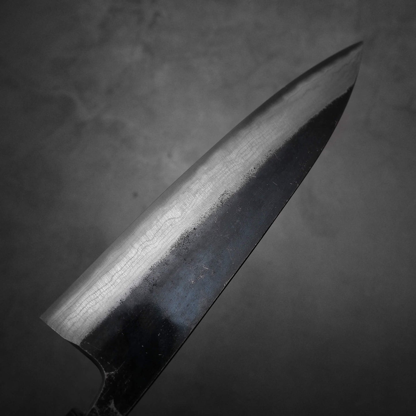 Top view of the blade of Hatsukokoro Kumokage gyuto knife. Image focuses on the left side of the blade