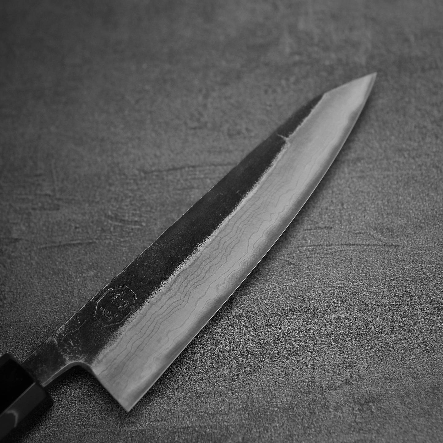 Close up view of the blade of Hatsukokoro Kumokage kurouchi damascus aogami#2 honesuki knife
