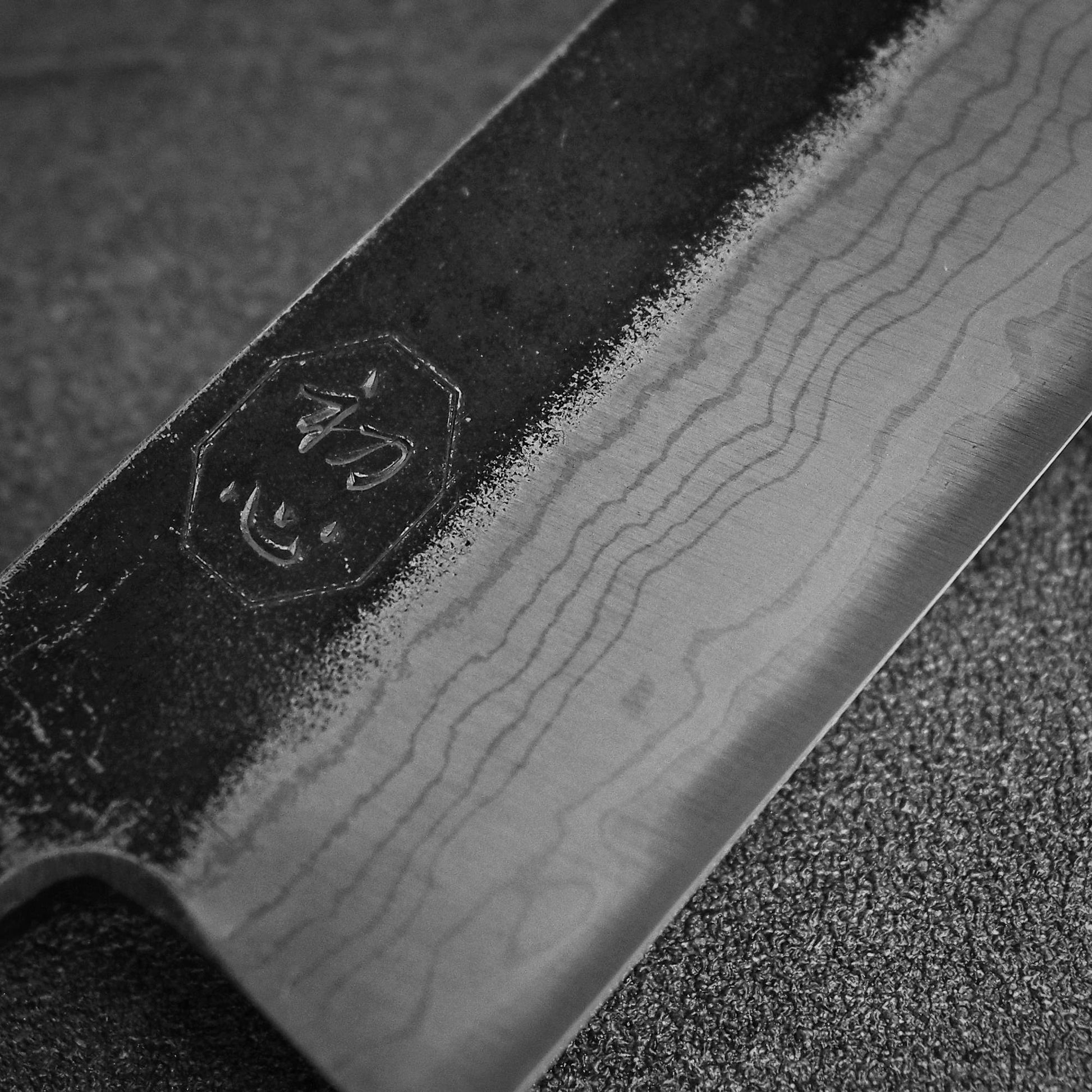 Close up view of the kanji of Hatsukokoro Kumokage kurouchi damascus aogami#2 honesuki knife