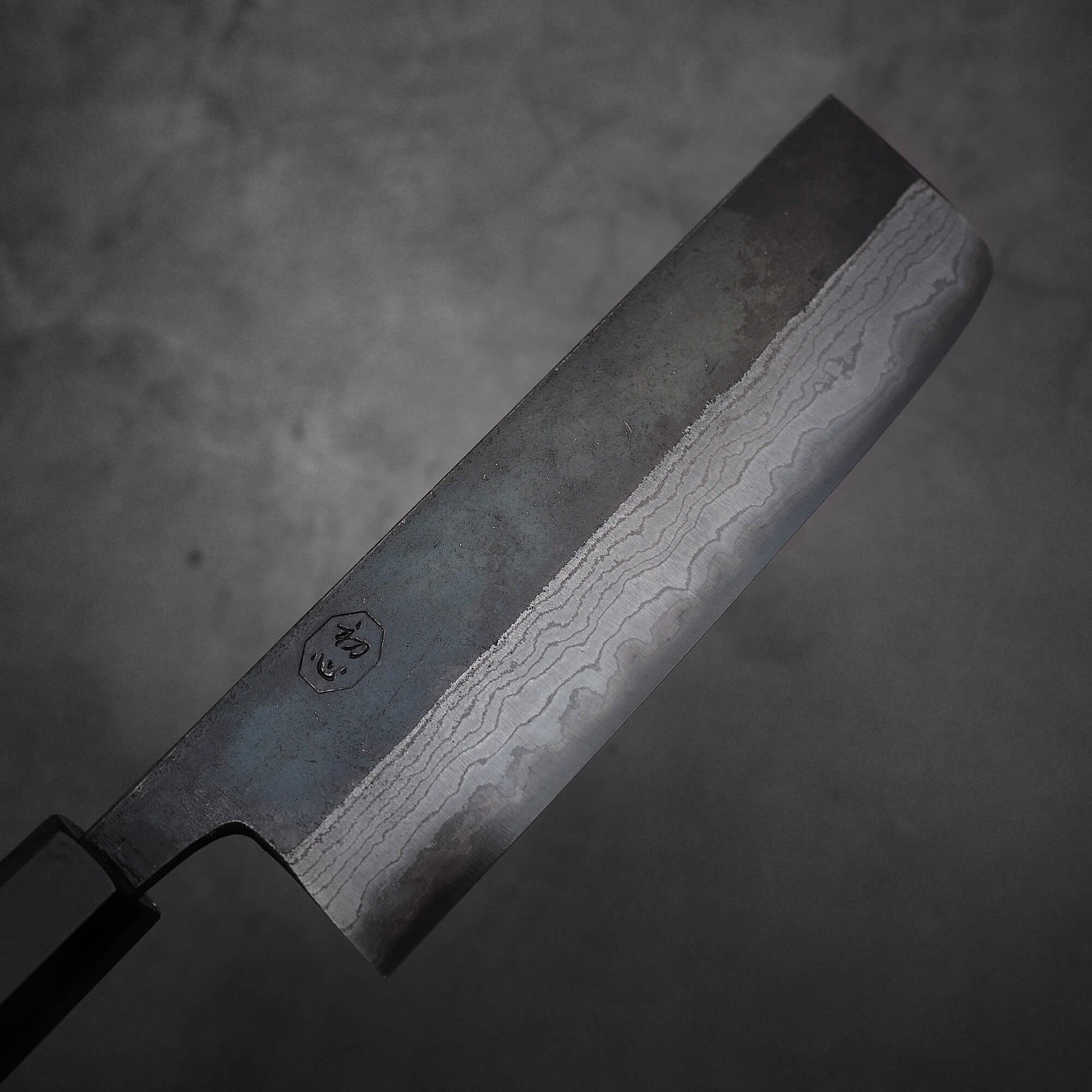 Top view of the blade of Hatsukokoro Kumokage kurouchi damascus aogami#2 nakiri knife. Image shows the right side of the blade