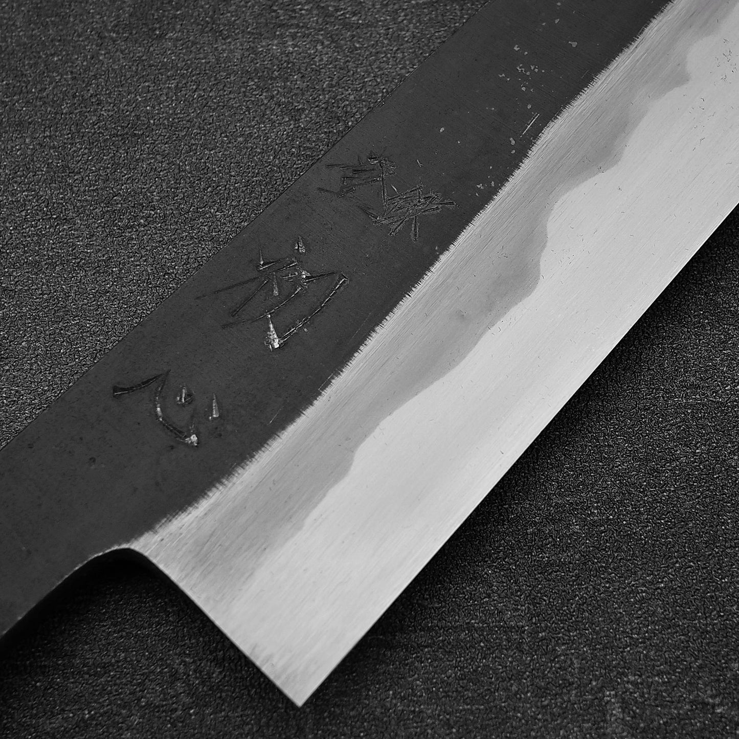 Close up view of the kanji of Hatsukokoro Yoake kurouchi aogami#1 kiritsuke gyuto knife