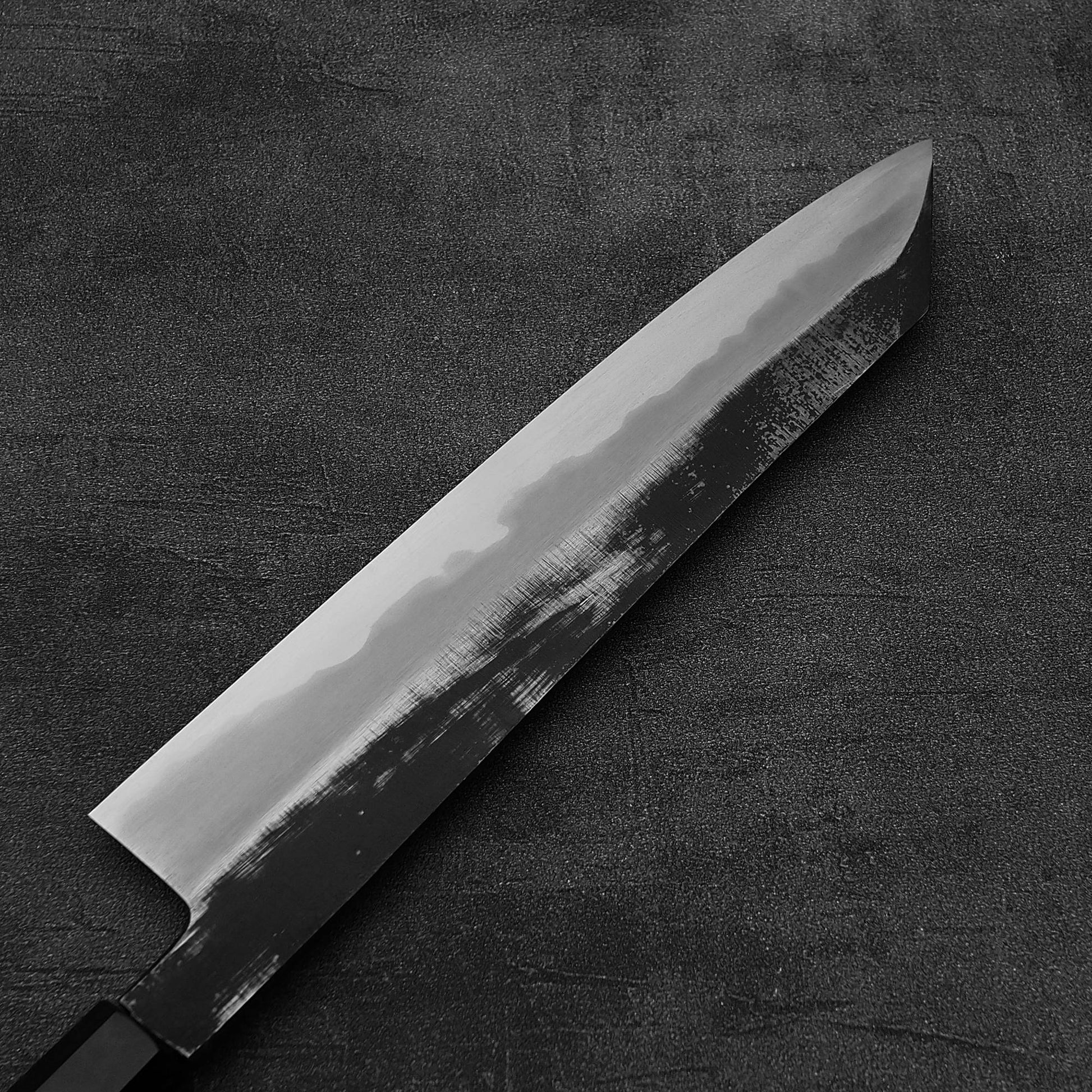 Close up view of the back side of Hatsukokoro Yoake kurouchi aogami#1 kiritsuke gyuto knife