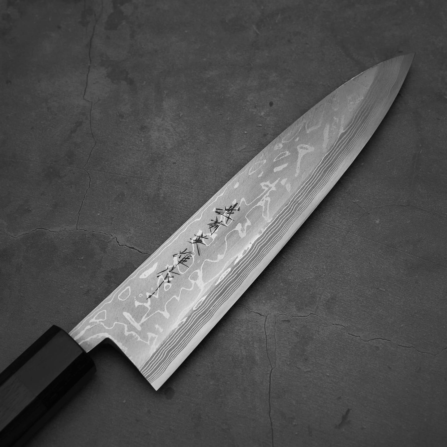 Top view of Hideo Kitaoka damascus aogami#2 mioroshi deba 210mm. Image focuses on the right side of the blade