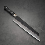 Top view of Ittosai Kotetsu tsuchime kurouchi aogami super kiritsuke gyuto in diagonal postion where the tip is facing lower right