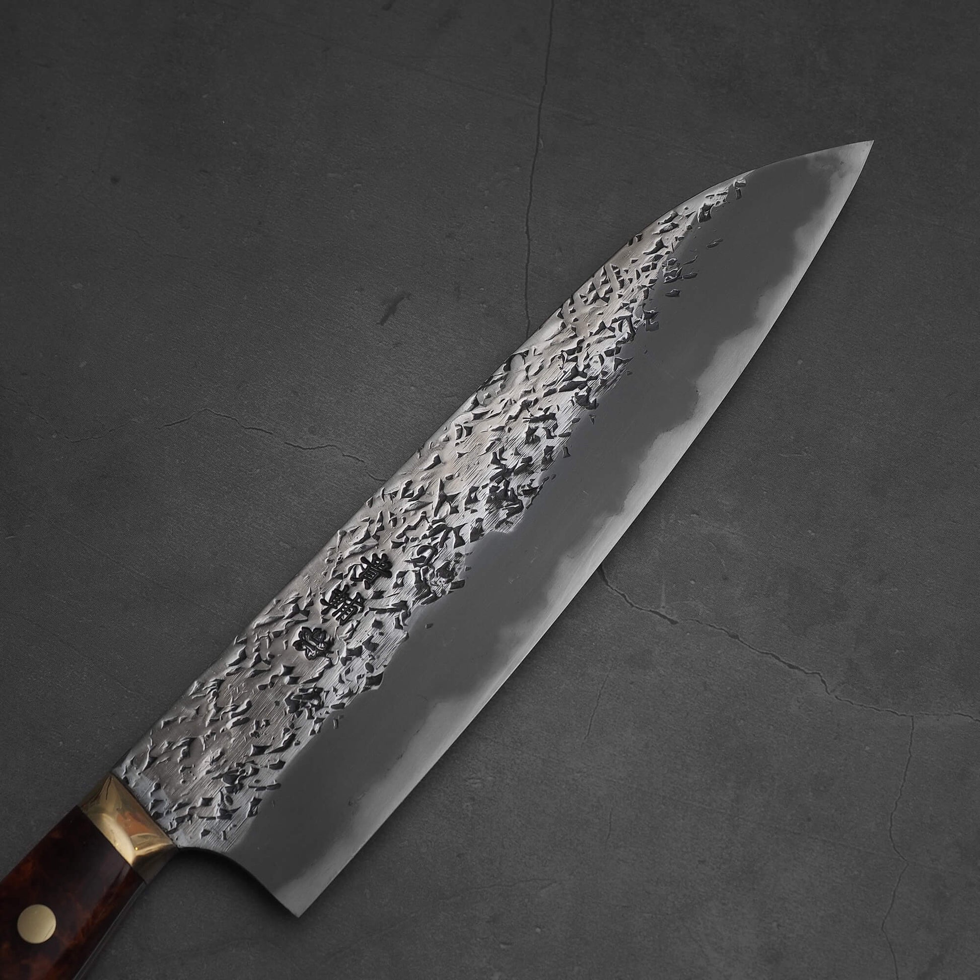 Top view of 220mm Kisuke Manaka tsuchime honwarikomi shirogami#2 gyuto knife. Image shows the right side of the blade