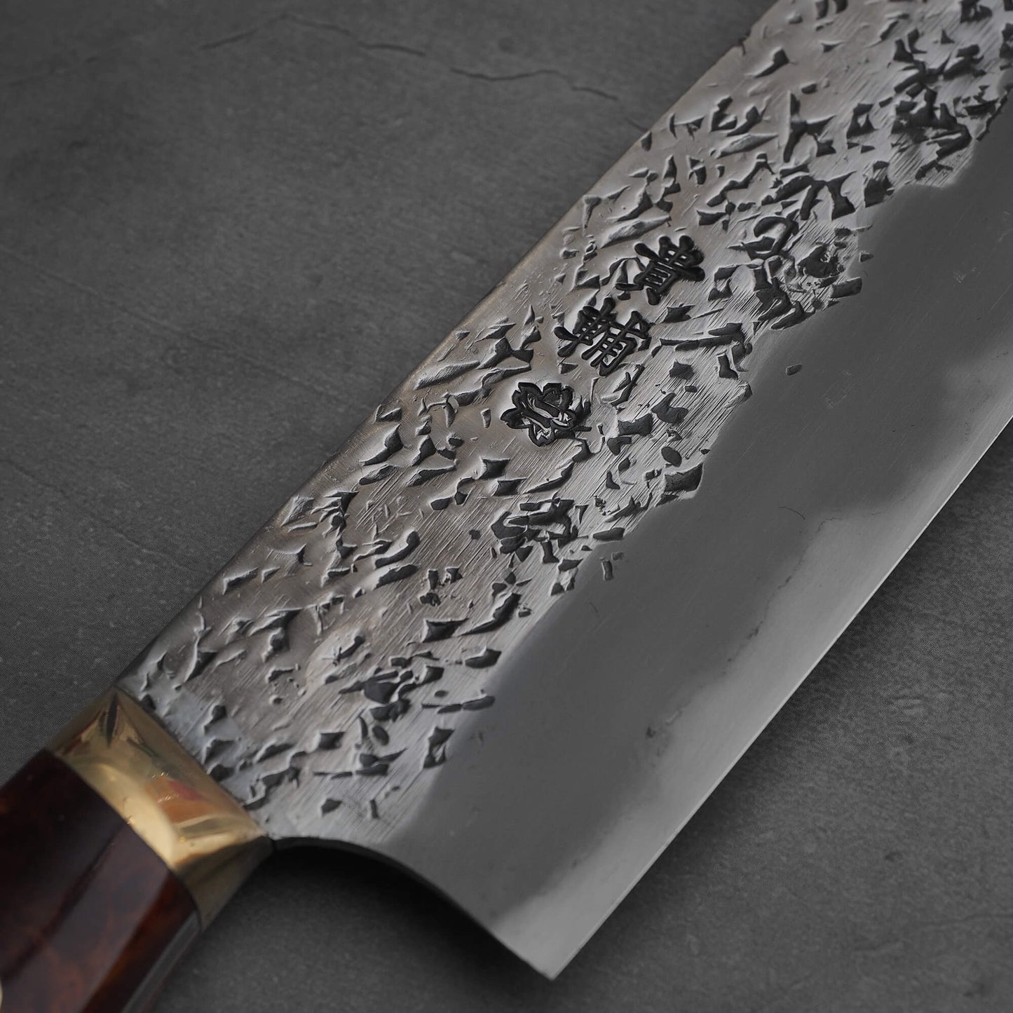 Close up view of 220mm Kisuke Manaka tsuchime honwarikomi shirogami#2 gyuto knife. Image focuses on the kanji area