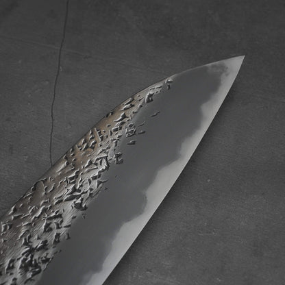 Close up view of 220mm Kisuke Manaka tsuchime honwarikomi shirogami#2 gyuto knife. Image shows the tip area on the right side of the knife
