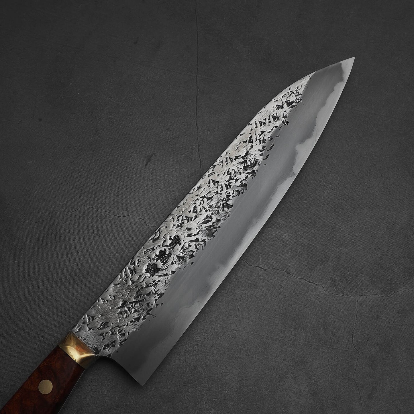 Top view of 240mm Kisuke Manaka tsuchime honwarikomi shirogami#2 gyuto knife. Image focuses on the right side of the knife