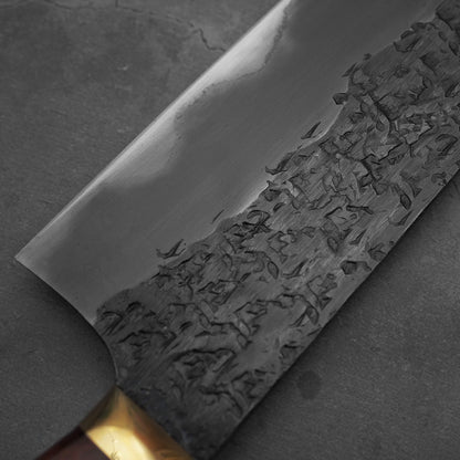 Close up view of the heel area of Kisuke Manaka tsuchime kurouchi white#2 gyuto 240mm western. Image shows left side of the knife