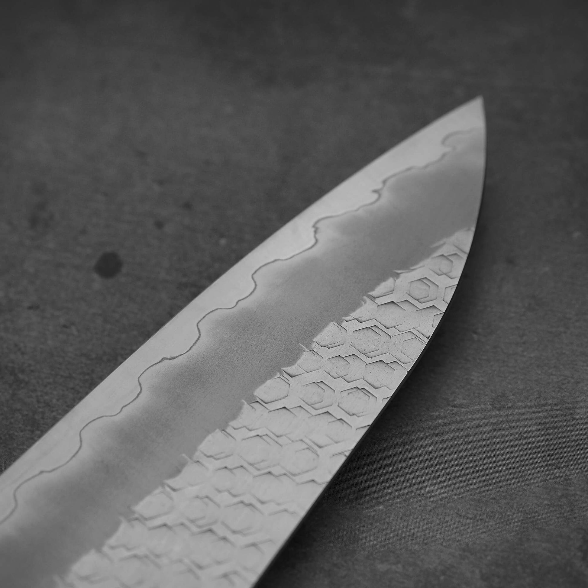 Close up view of the tip on the back side of 210mm Nigara tsuchime SG2 gyuto knife with blue handle
