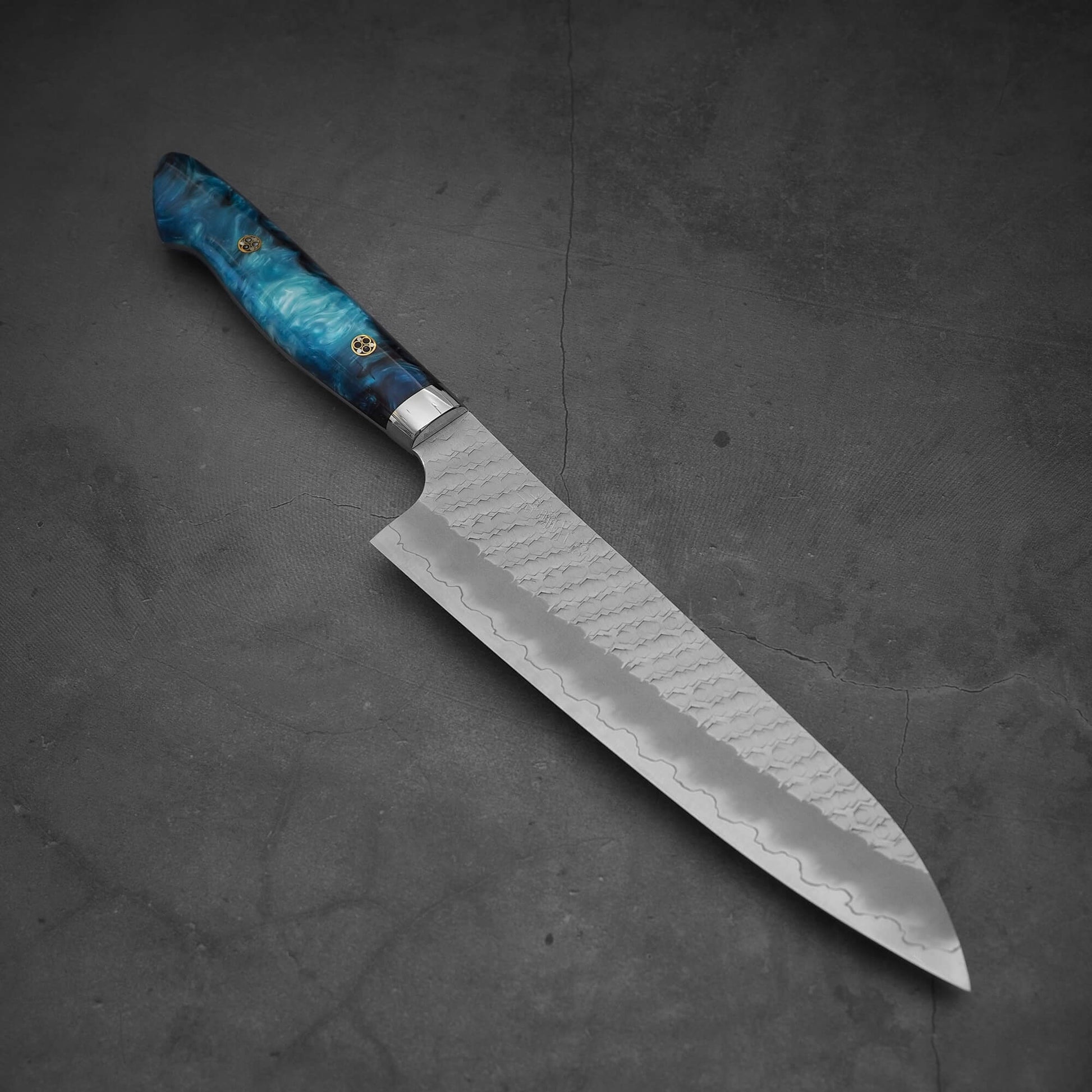 Top view of 210mm Nigara tsuchime SG2 gyuto knife with blue handle in diagonal position