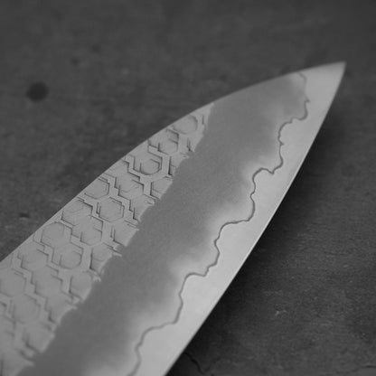 Close up view around the tip of 210mm Nigara tsuchime SG2 gyuto knife with blue handle