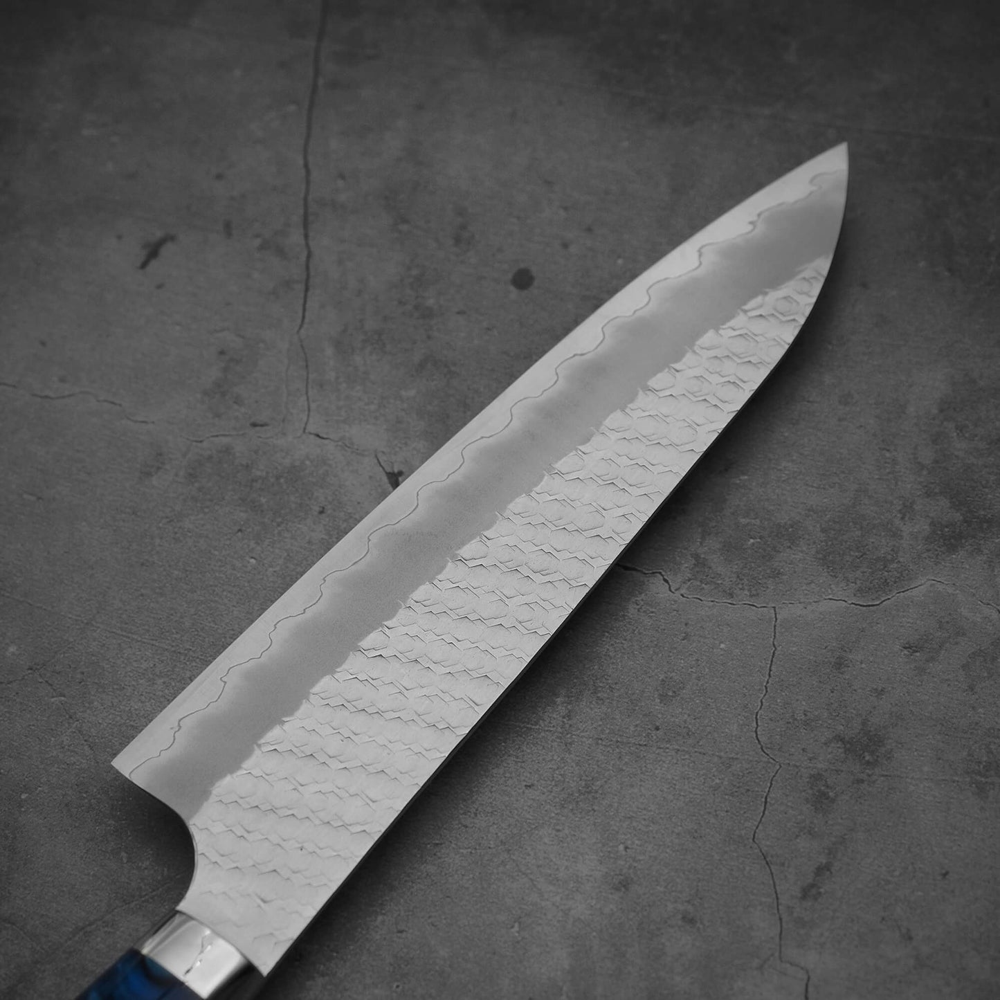 Top view of the blade of 210mm Nigara tsuchime SG2 gyuto knife with blue handle