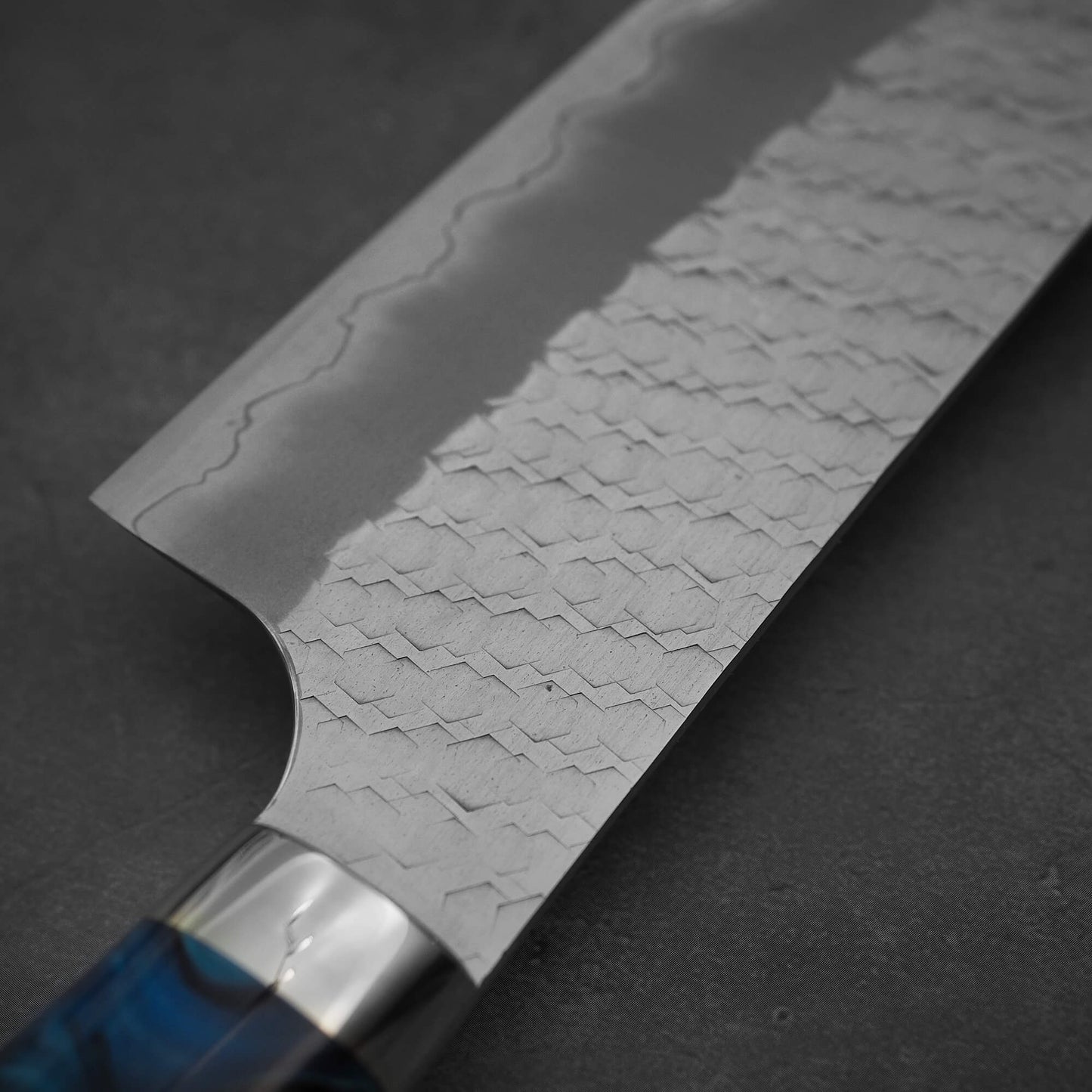 Close up view of the back side of 210mm Nigara tsuchime SG2 gyuto knife with blue handle
