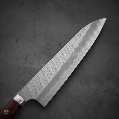Front view of the blade of 210mm Nigara tsuchime SG2 gyuto knife with red handle in diagonal position