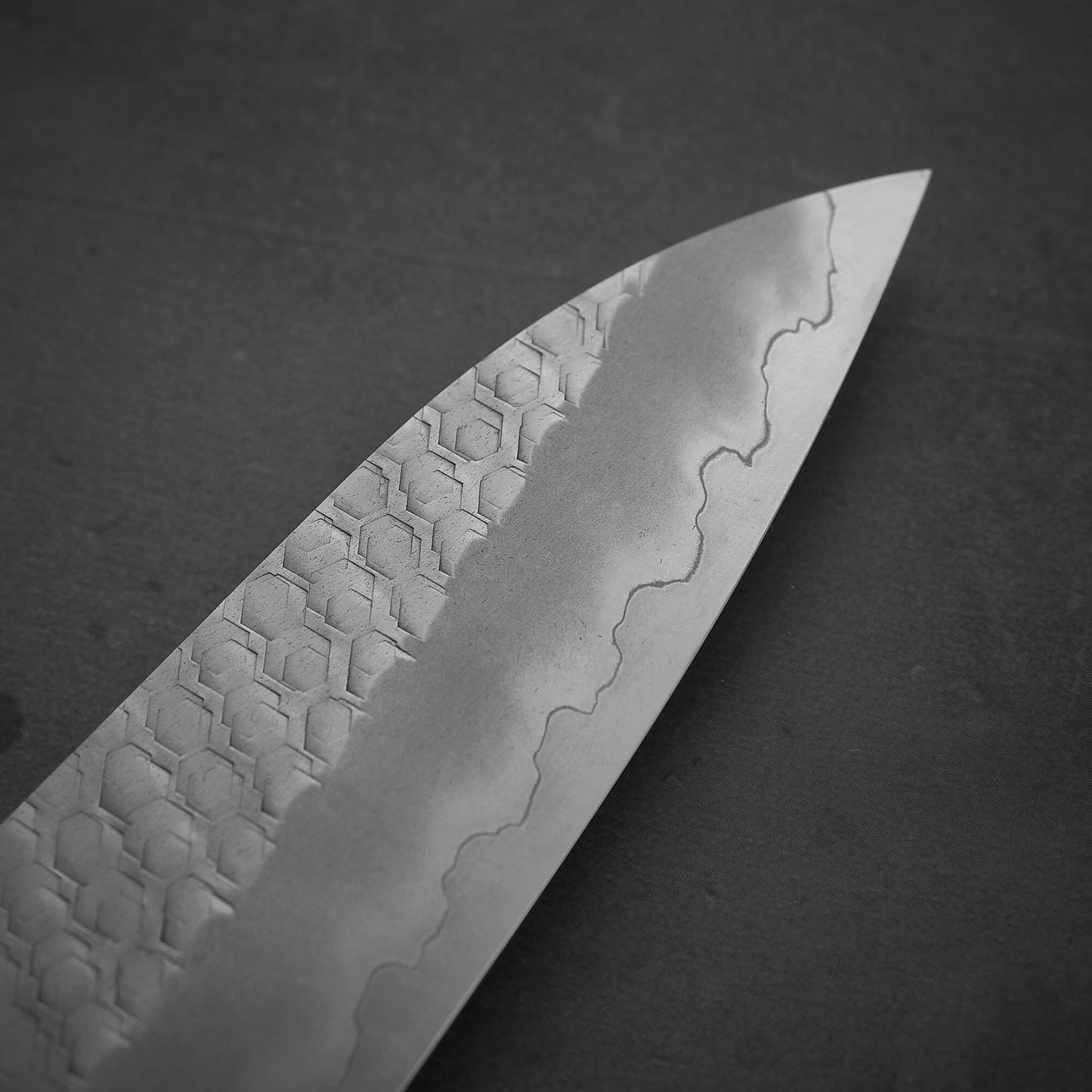 Close up view of the tip area of 210mm Nigara tsuchime SG2 gyuto knife with red handle
