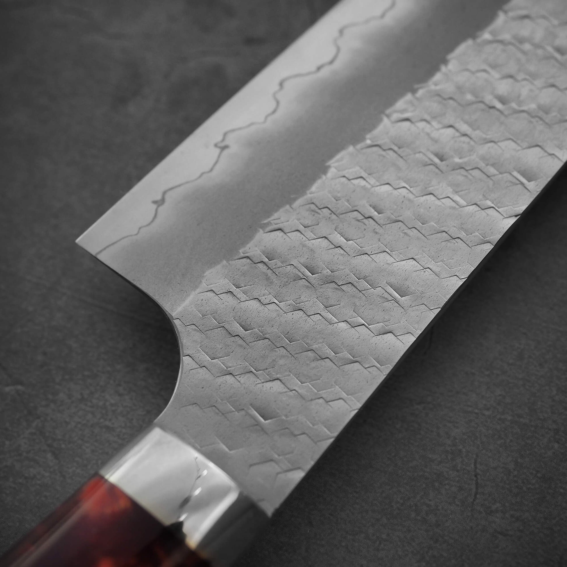 Close up view on the back side of the blade of 210mm Nigara tsuchime SG2 gyuto knife with red handle