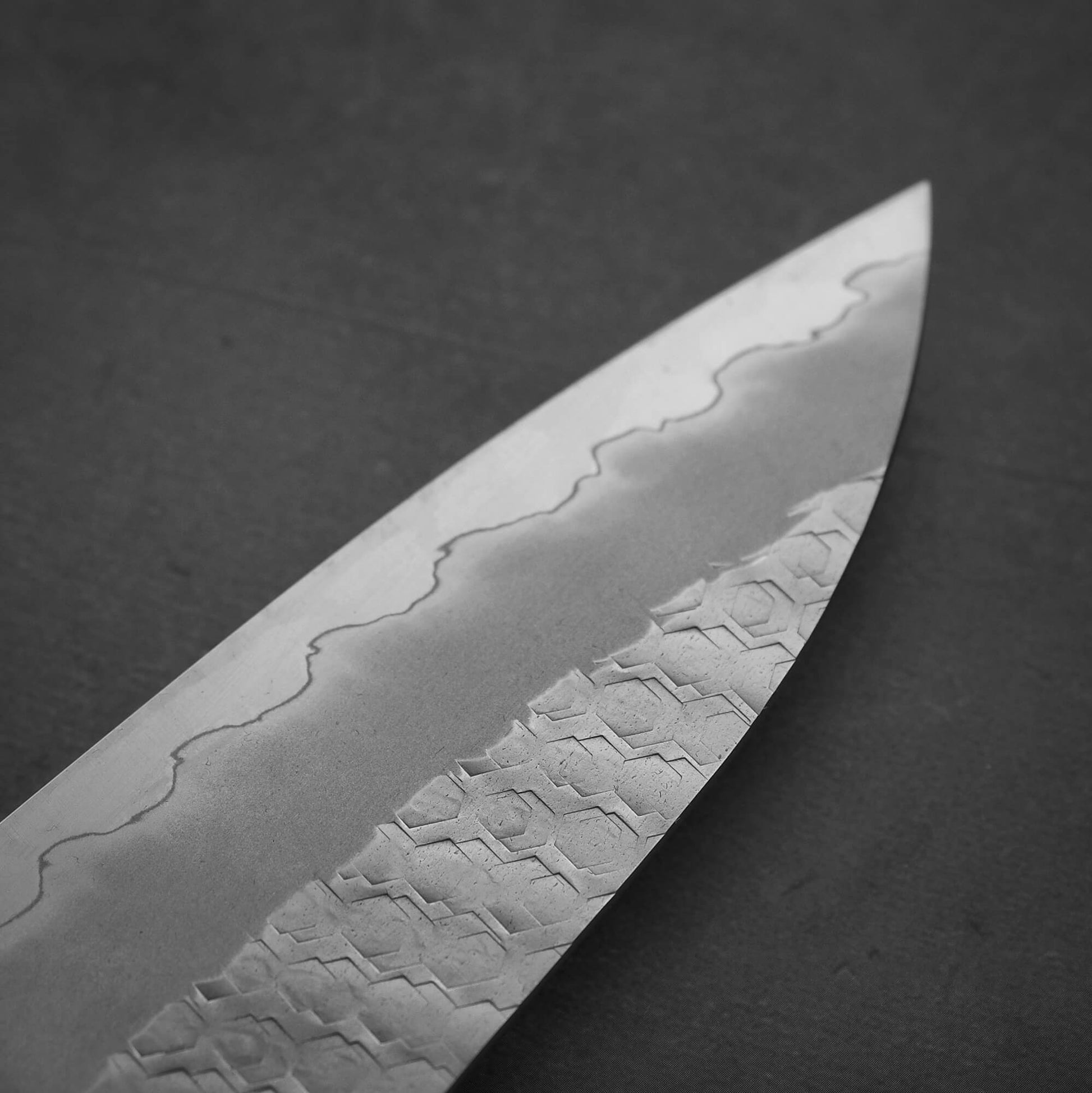 Close up view around the tip area on the back side of 210mm Nigara tsuchime SG2 gyuto knife with red handle