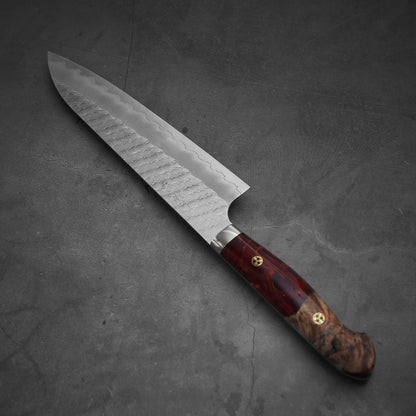Top view of 210mm Nigara tsuchime SG2 gyuto knife with red handle where tip is pointing upper left