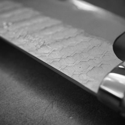 Close up view of the spine of 210mm Nigara tsuchime SG2 gyuto knife with pearl handle resin