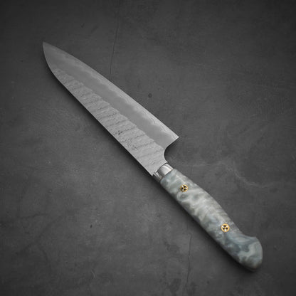 Top view of 210mm Nigara tsuchime SG2 gyuto knife with pearl handle resin in diagonal position where the tip is pointing on the upper left