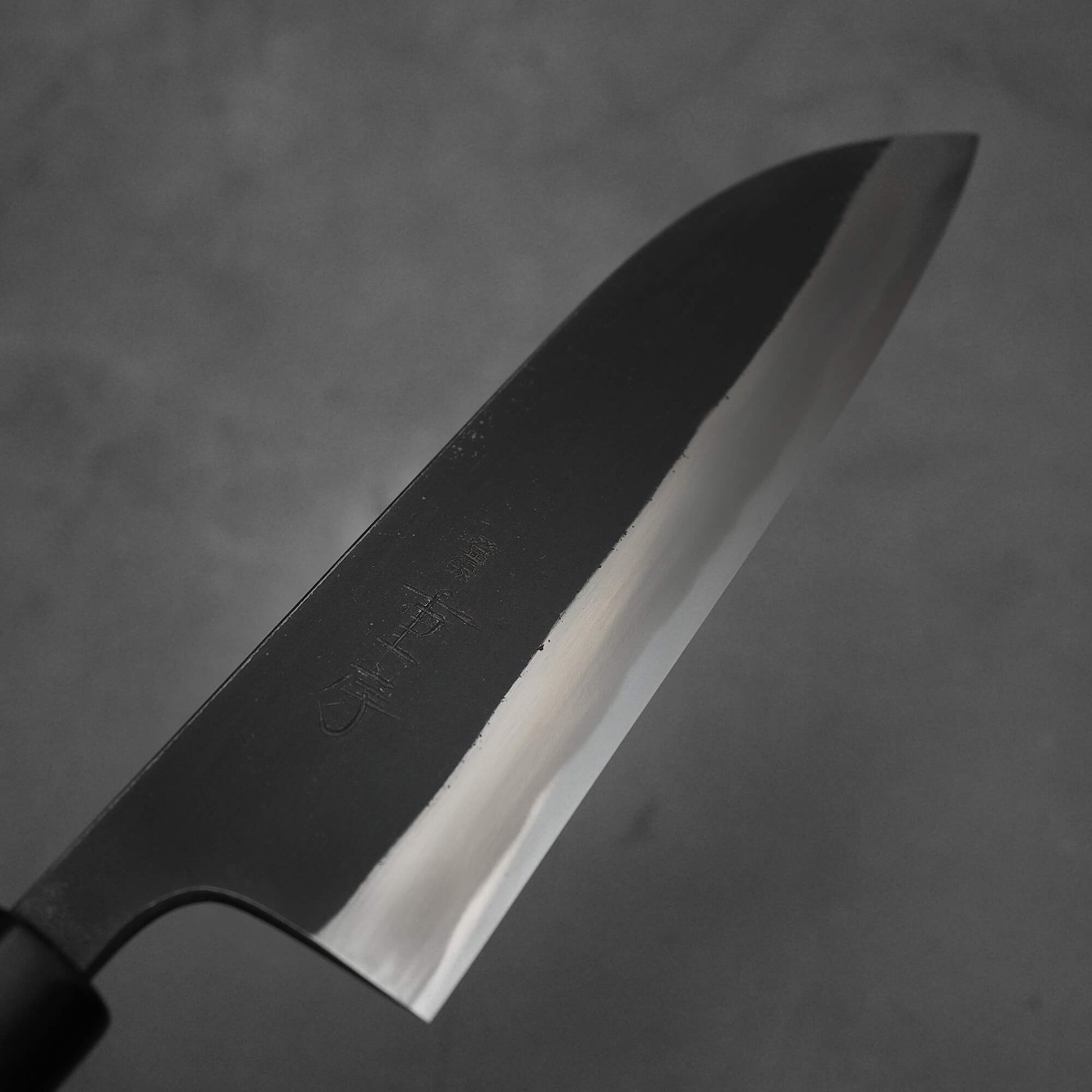 Top view of the blade of Shigefusa kurouchi 165mm santoku. Image focuses on the right side of the blade